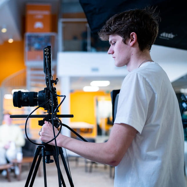 Elev på Medier og kommunikasjon med filmkamera på produksjon