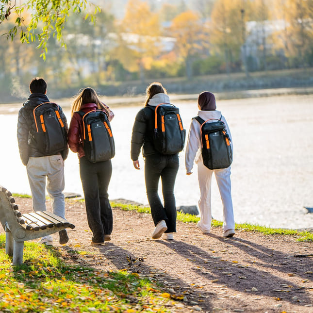 Fire elever fra Akademiet VGS går langs elvebredden
