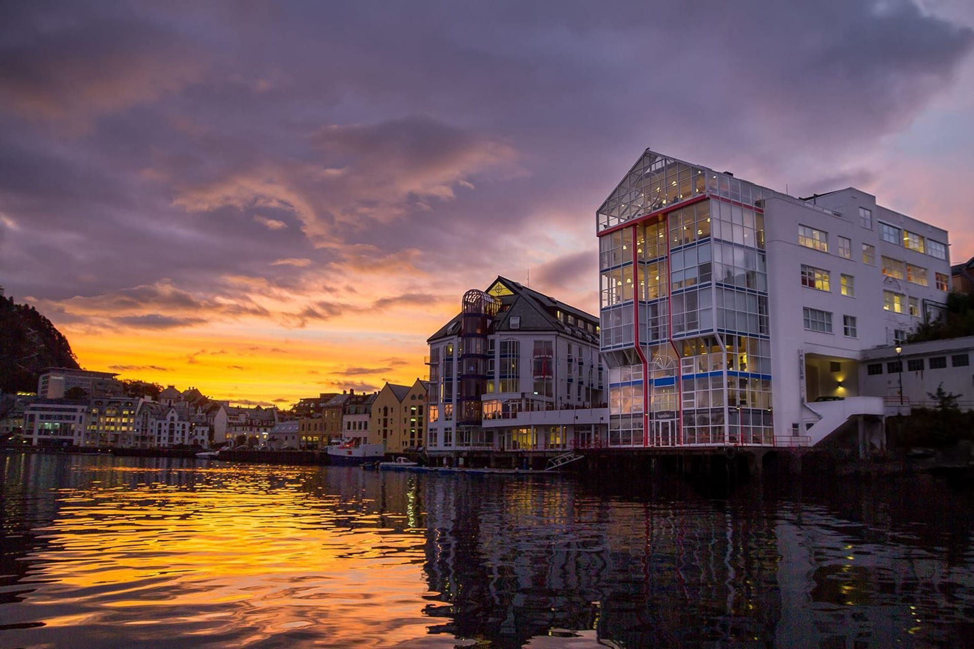 Akademiet VGS Ålesund hvor bygget sees ved vannkanten og i solnedgang