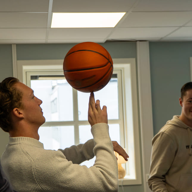 Elev tar basketball på en finger