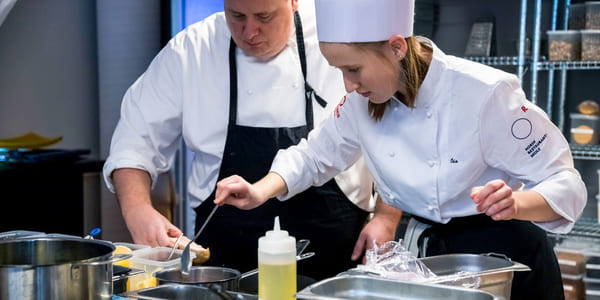 Lærer og elev jobber fokusert med matpresentasjon på Akademiet Norsk Restaurantskole