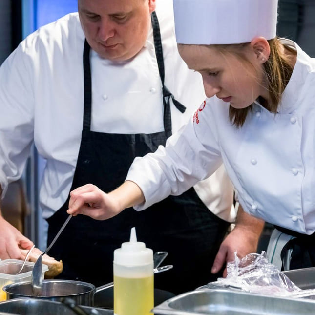 Lærer og elev jobber fokusert med matpresentasjon på Akademiet Norsk Restaurantskole