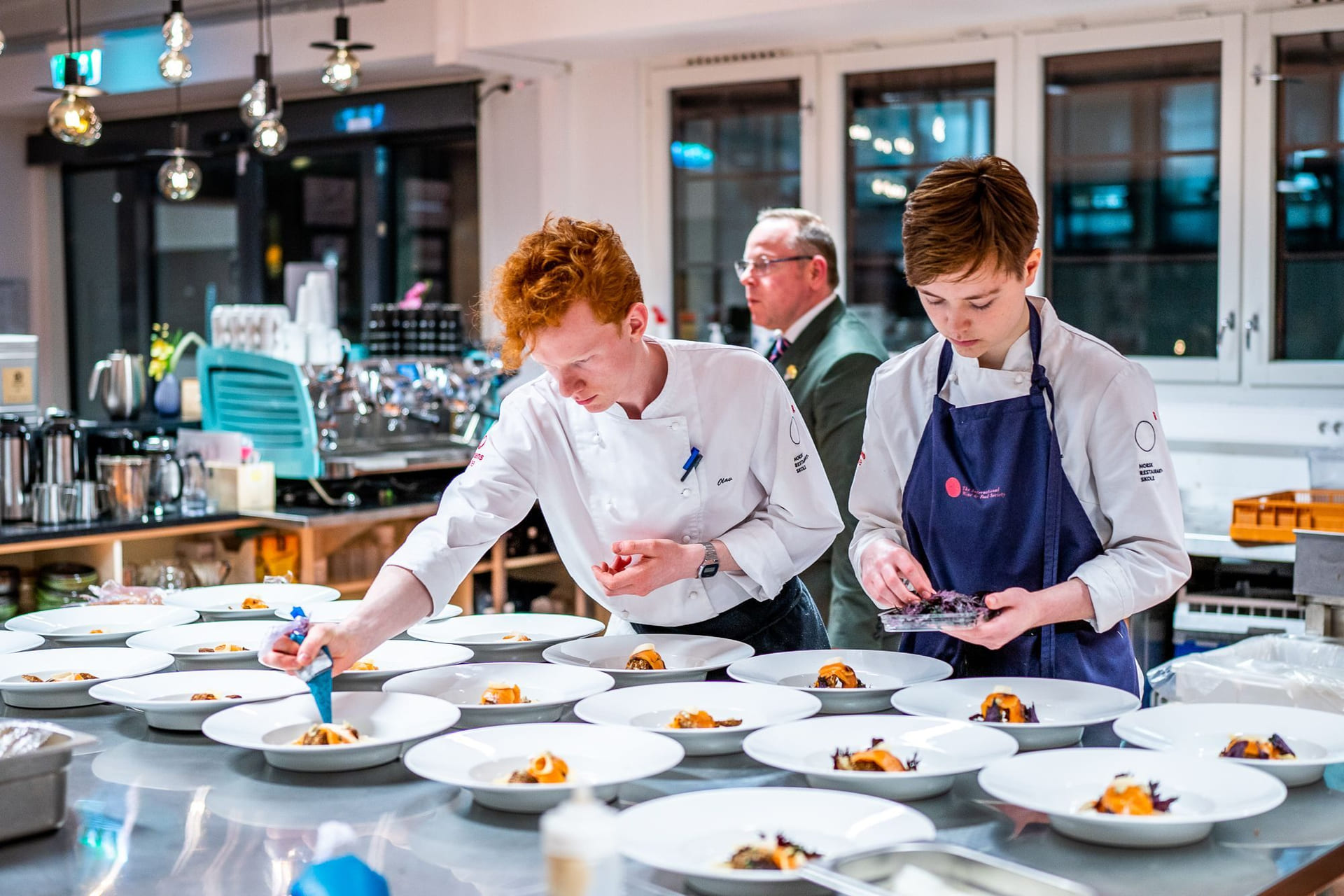 Elever på Akademiet Norsk Restaurantskole tilbereder retter til servering