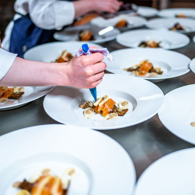 Elev danderer tallerken på Akademiet Norsk Restaurantskole