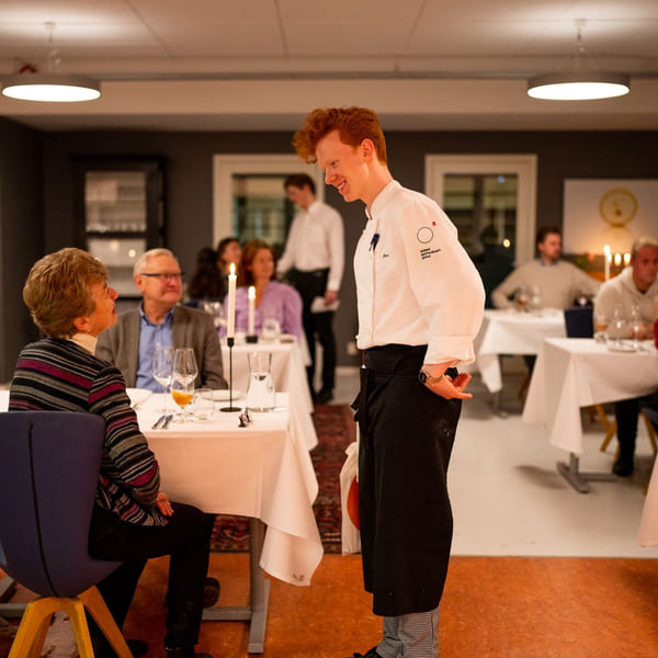 Elev serverer mat fra Akademiet Norsk Restaurantskole