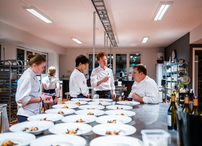 Elever på Akademiet Norsk Restaurantskole tilbereder retter til servering