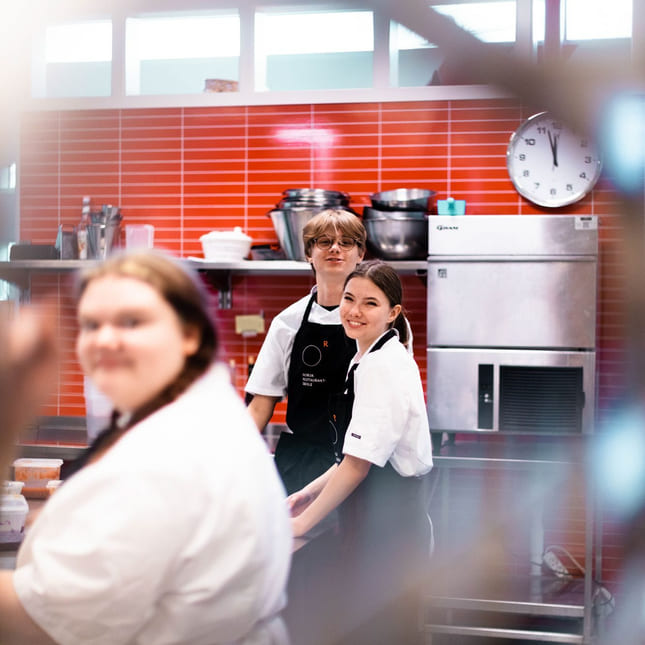 Elever på Akademiet Norsk Restaurantskole tilbereder mat på kjøkkenet