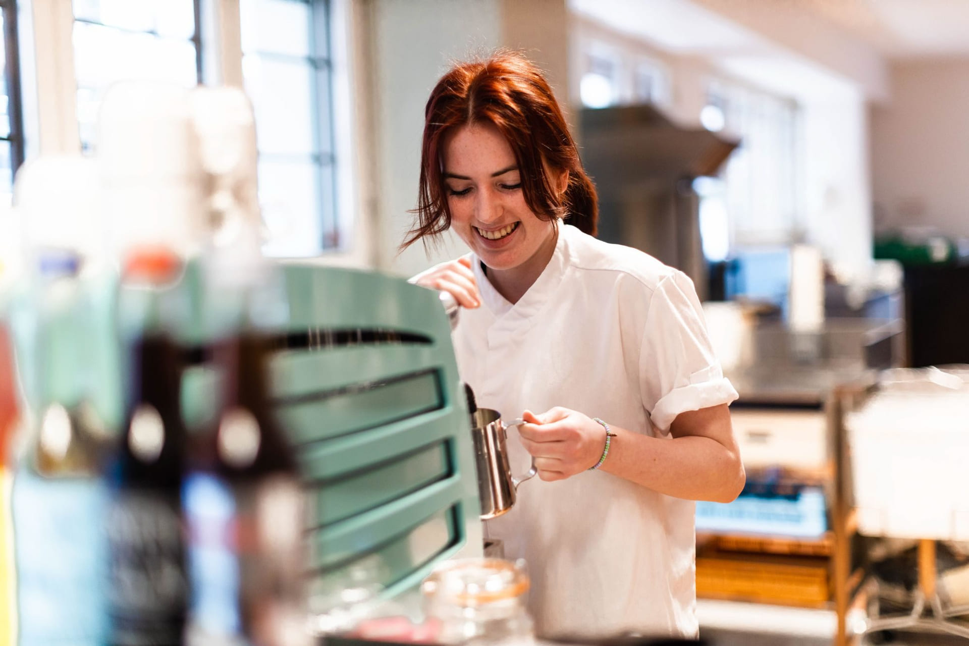 Elev på Akademiet Norsk Restaurantskole smiler mens hun lager kaffe