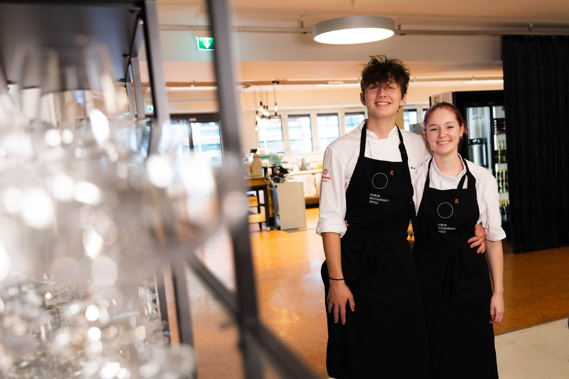 Elever på Akademiet Norsk Restaurantskole smiler med forkler på