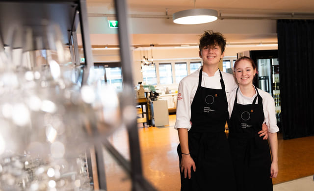 Elever på Akademiet Norsk Restaurantskole smiler med forkler på