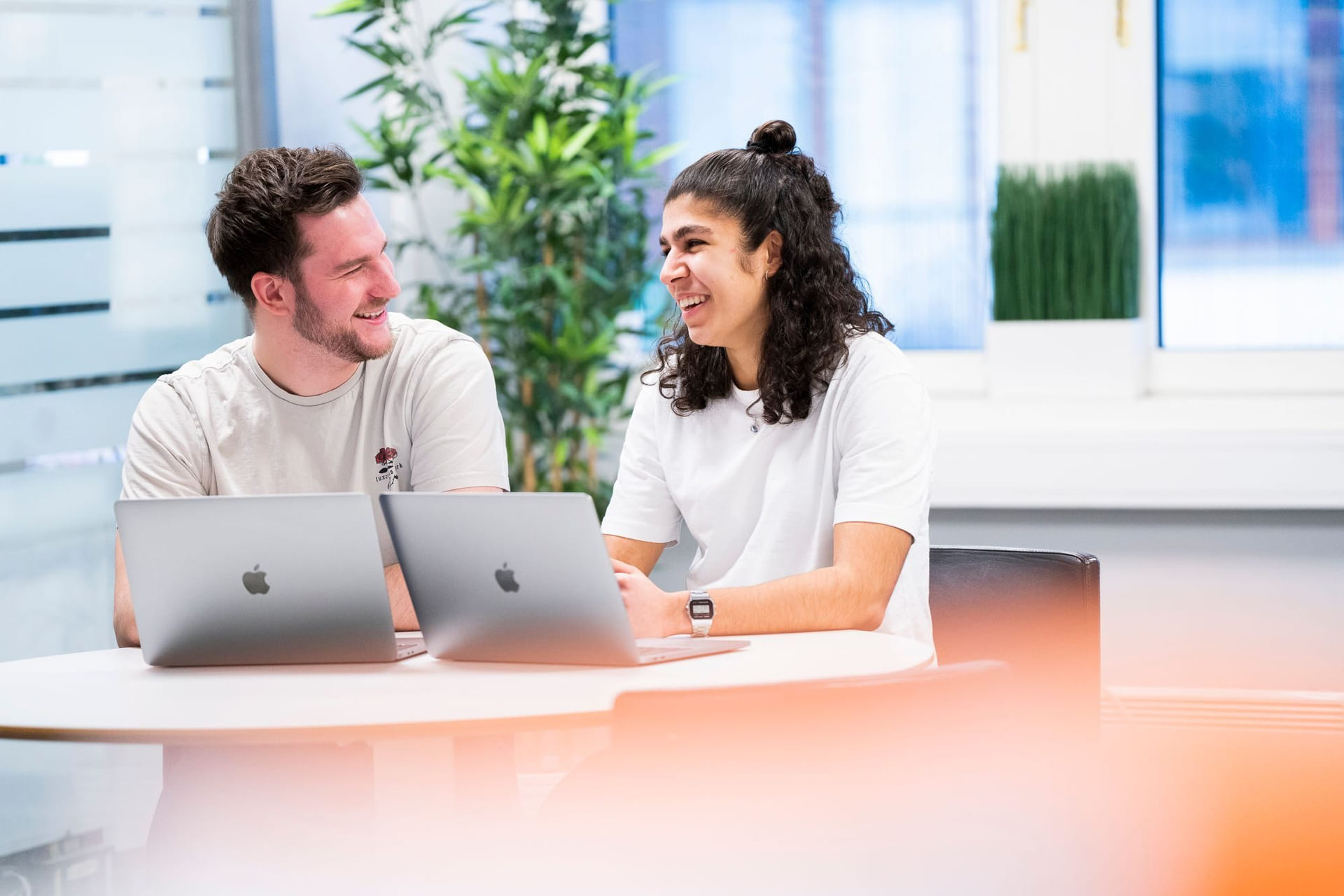 To privatister fra Akademiet Privatistskole sitter ved et bord og jobber med en MacBook