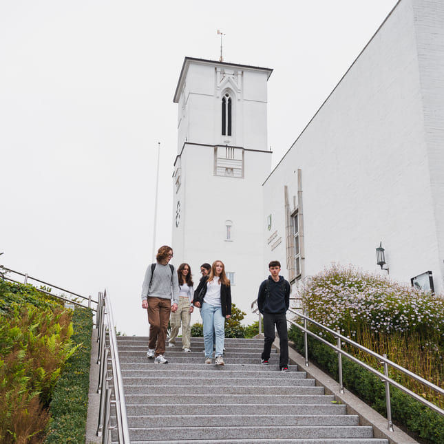 Elever fra Akademiet i Sandvika går nedover en trapp i Sandvika