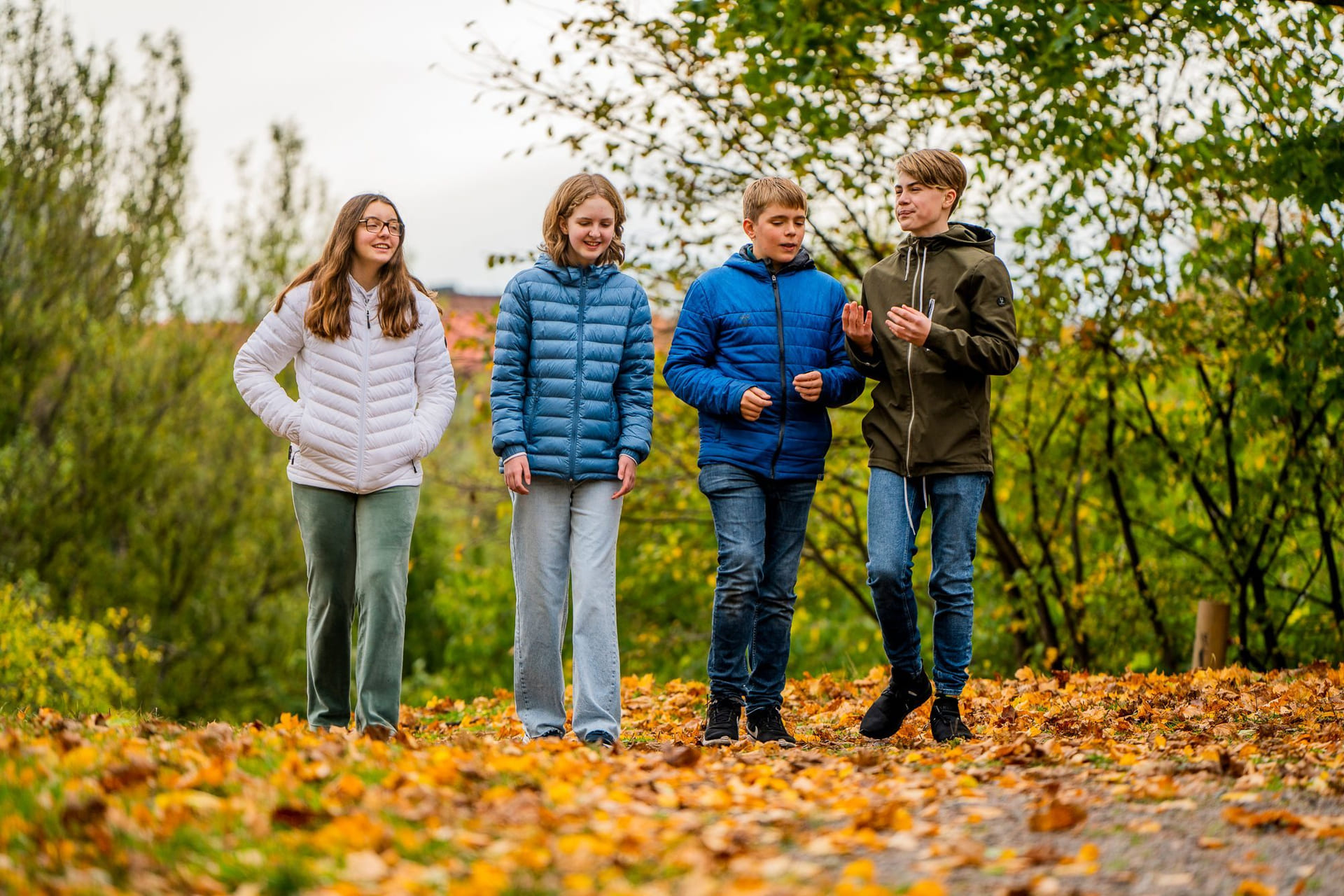 Elever på Akademiet Realfagsskole Oslo går i høstløvet utenfor skolen