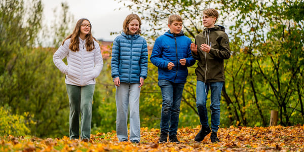 Elever på Akademiet Realfagsskole Oslo går i høstløvet utenfor skolen