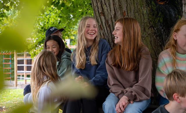 Elever på Akademiet Realfagsskole Oslo sitter ute på lekeplassen