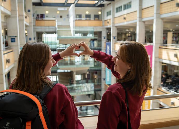 To elever lager et hjerte med hendene på York College i England