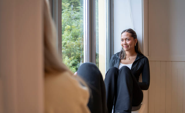Elev sitter i vinduskarmen på Akademiet Ålesund