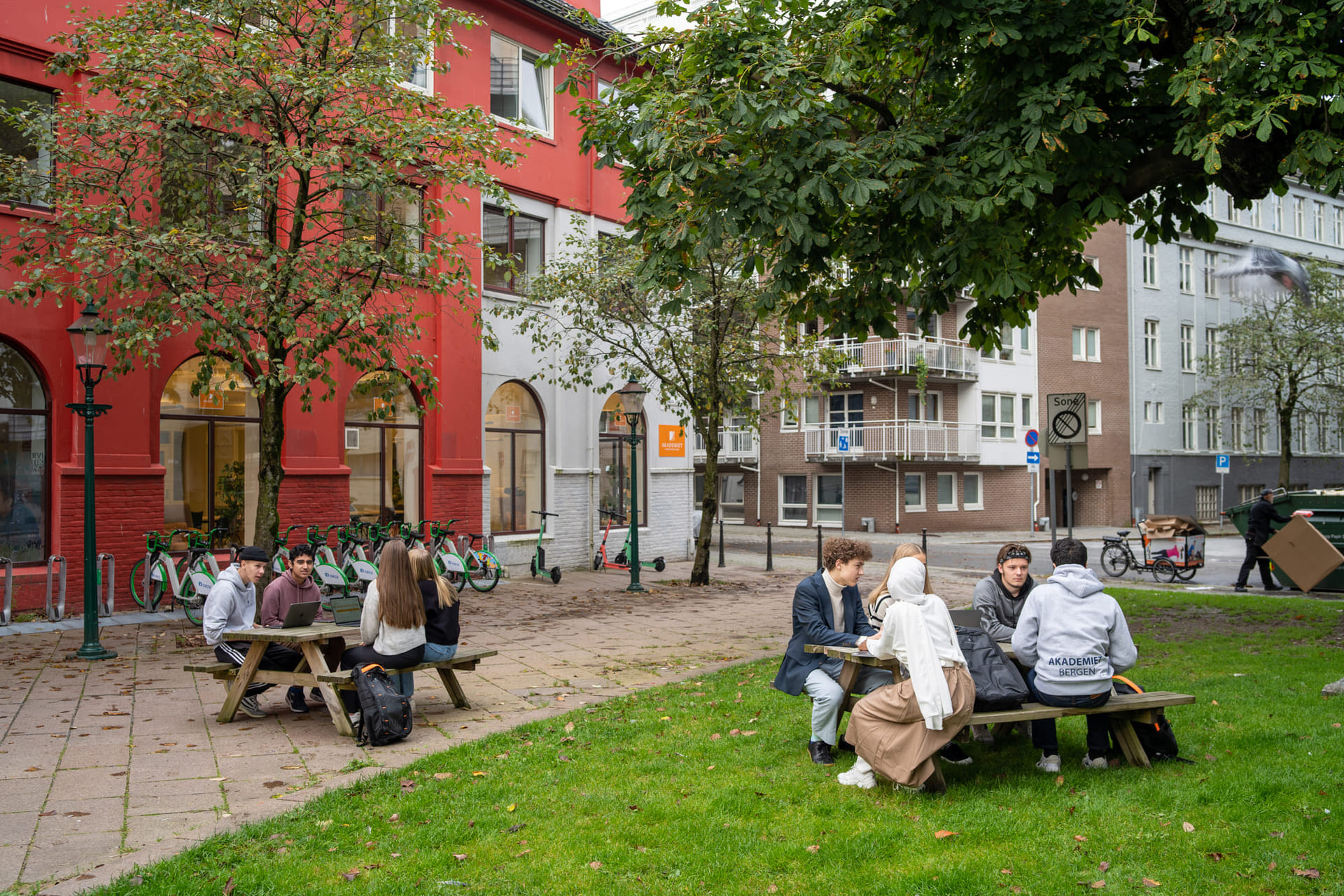 elever sitter utenfor akademiet vgs bergen og jobber med skole