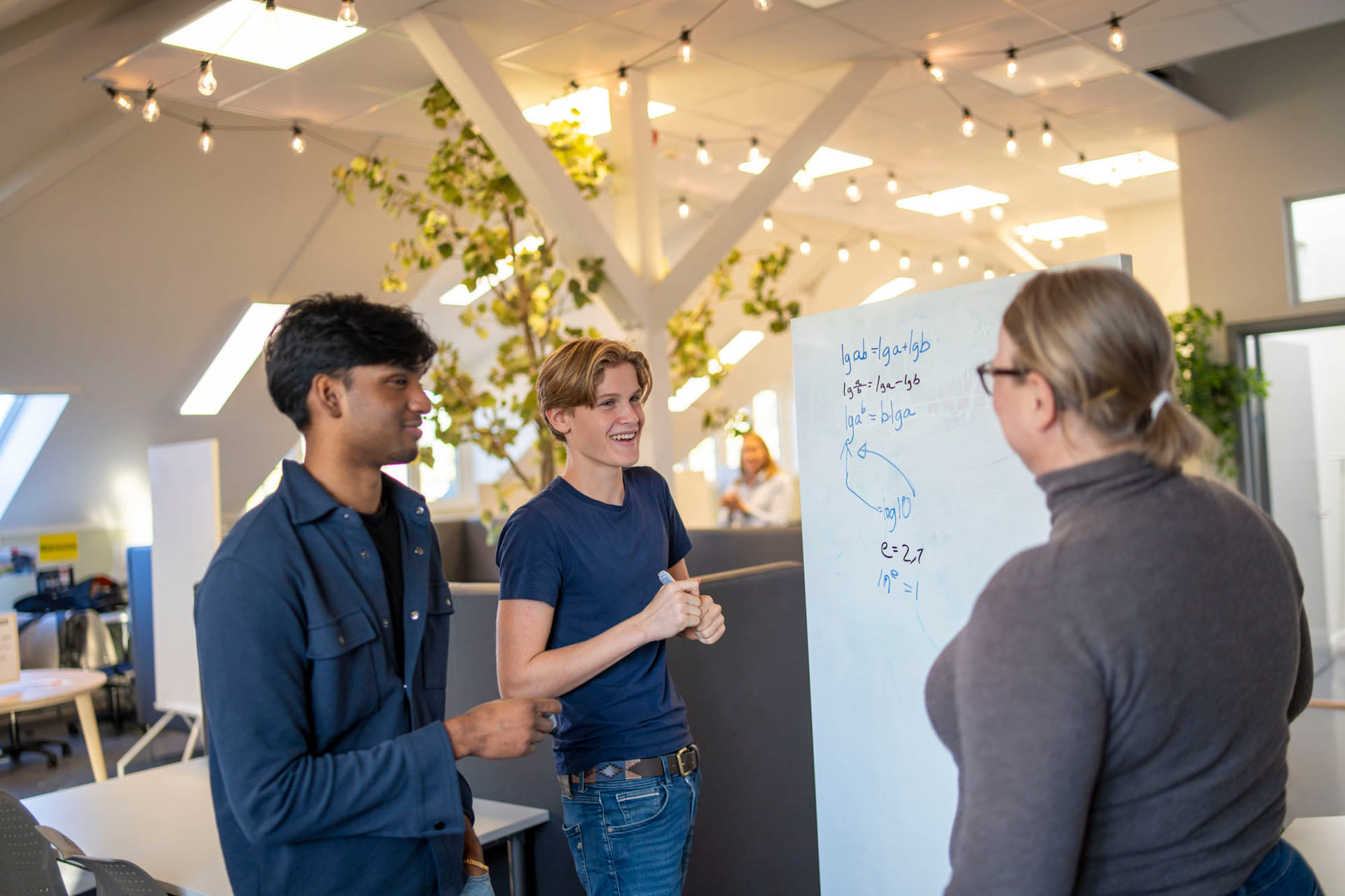Elever og mentor jobber med fag på tavle.