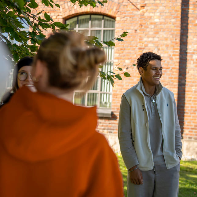 Elever står utenfor skolen på Akademiet VGS Drammen Sundland