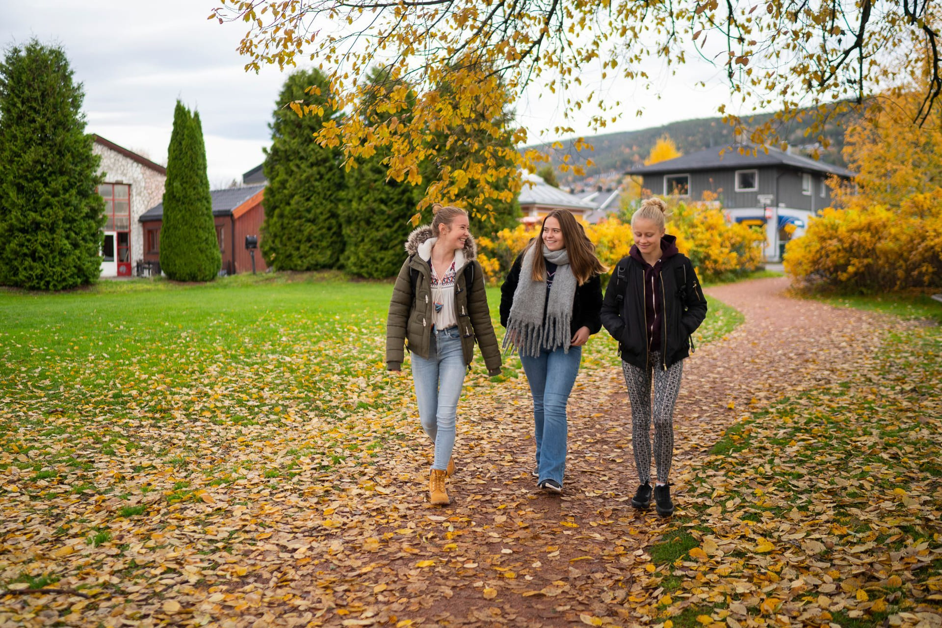 Tre elever går langs elva på Akademiet VGS Heltberg Drammen
