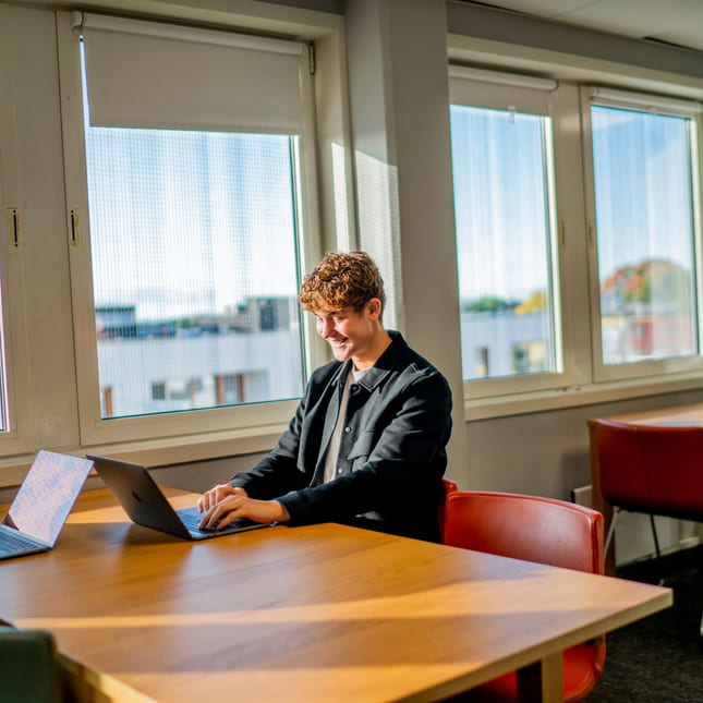 Elev på Akademiet jobber på Macbook