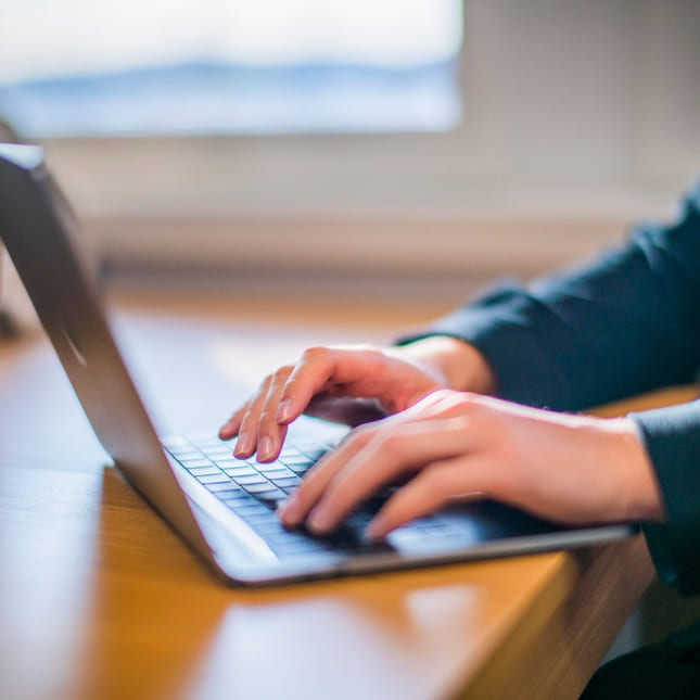 Elev skriver på macbook på Akademiet