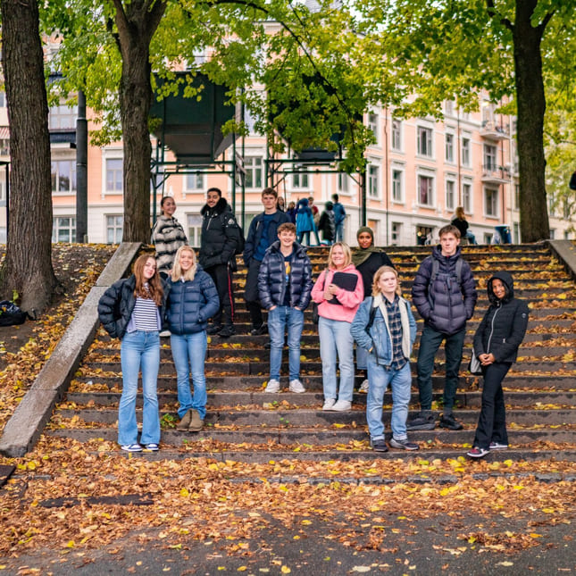 Elever på Akademiet står i en trapp utenfor Akademiet Videregående Skole