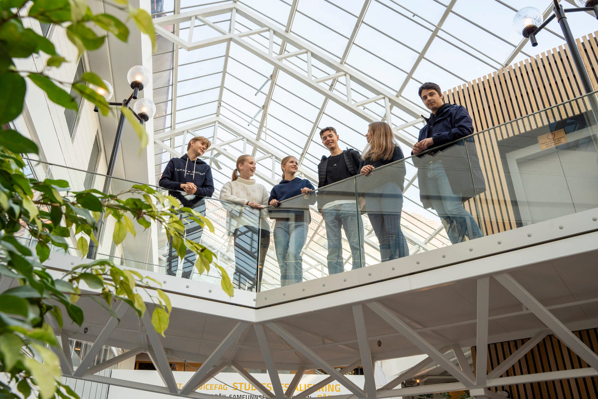 Elever står på en innendørs bro på Akademiet VGS Sandnes