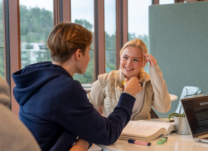 To elever snakker sammen i studietid på Akademiet.