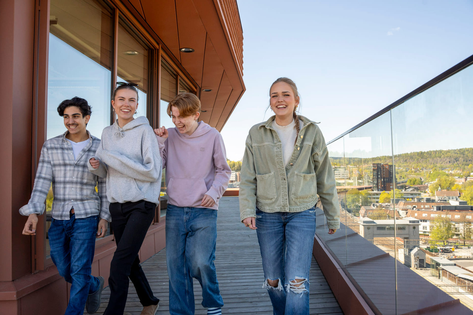 Elevgruppe går og smiler utenfor Akademiet VGS Sandvika
