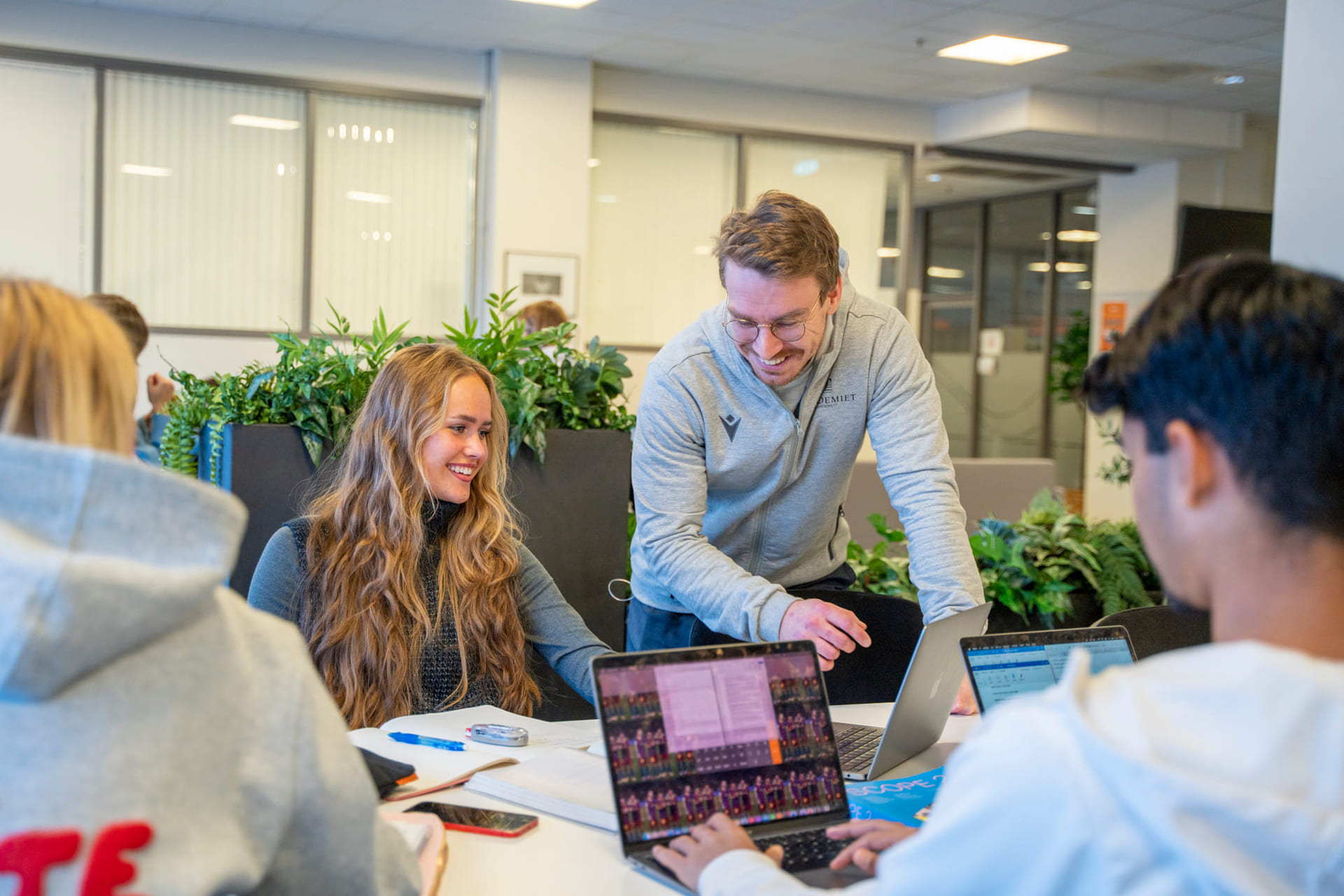 Elevsnakker med mentor mens hun jobber med skole i veiledningstid på Akademiet VGS Kristiansand.