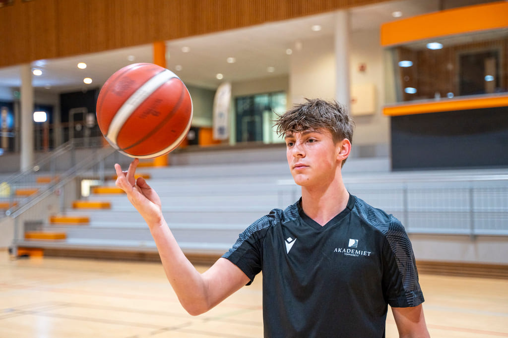 Elev spinner basketballen på fingeren