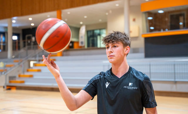 Elev spinner basketballen på fingeren