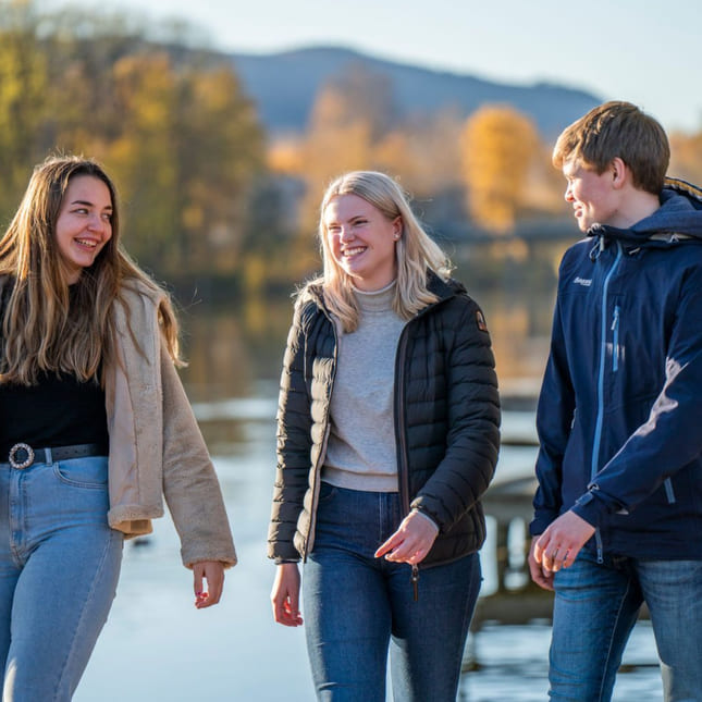 Tre elever går langs elvebredden i Drammen