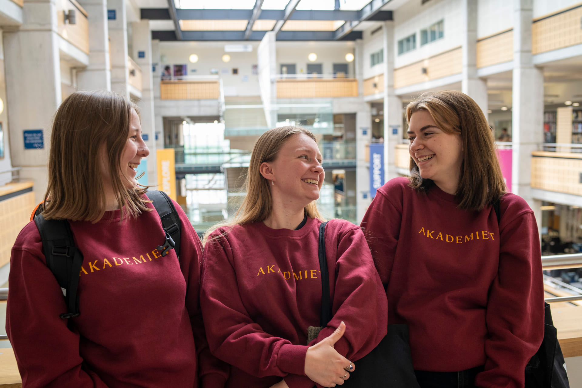 Tre elever står ved siden av hverandre og snakker i fellesområdet på York College.