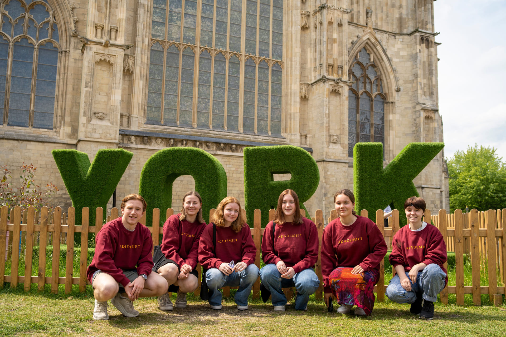 Elever poserer utenfor store bokstaver "YORK" i England.