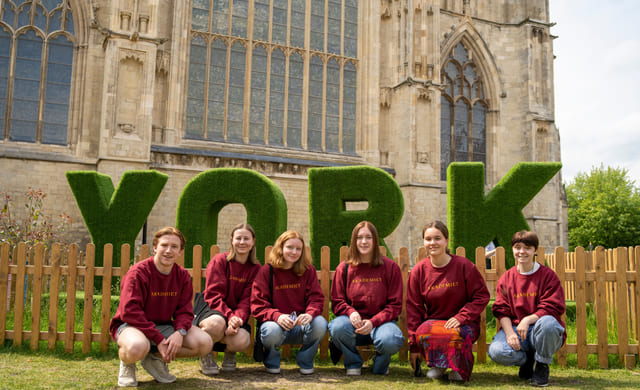 Elever poserer utenfor store bokstaver "YORK" i England.
