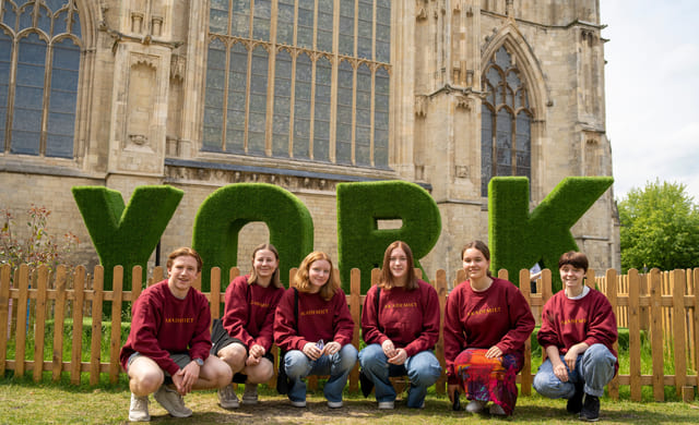 Elever poserer utenfor store bokstaver "YORK" i England.