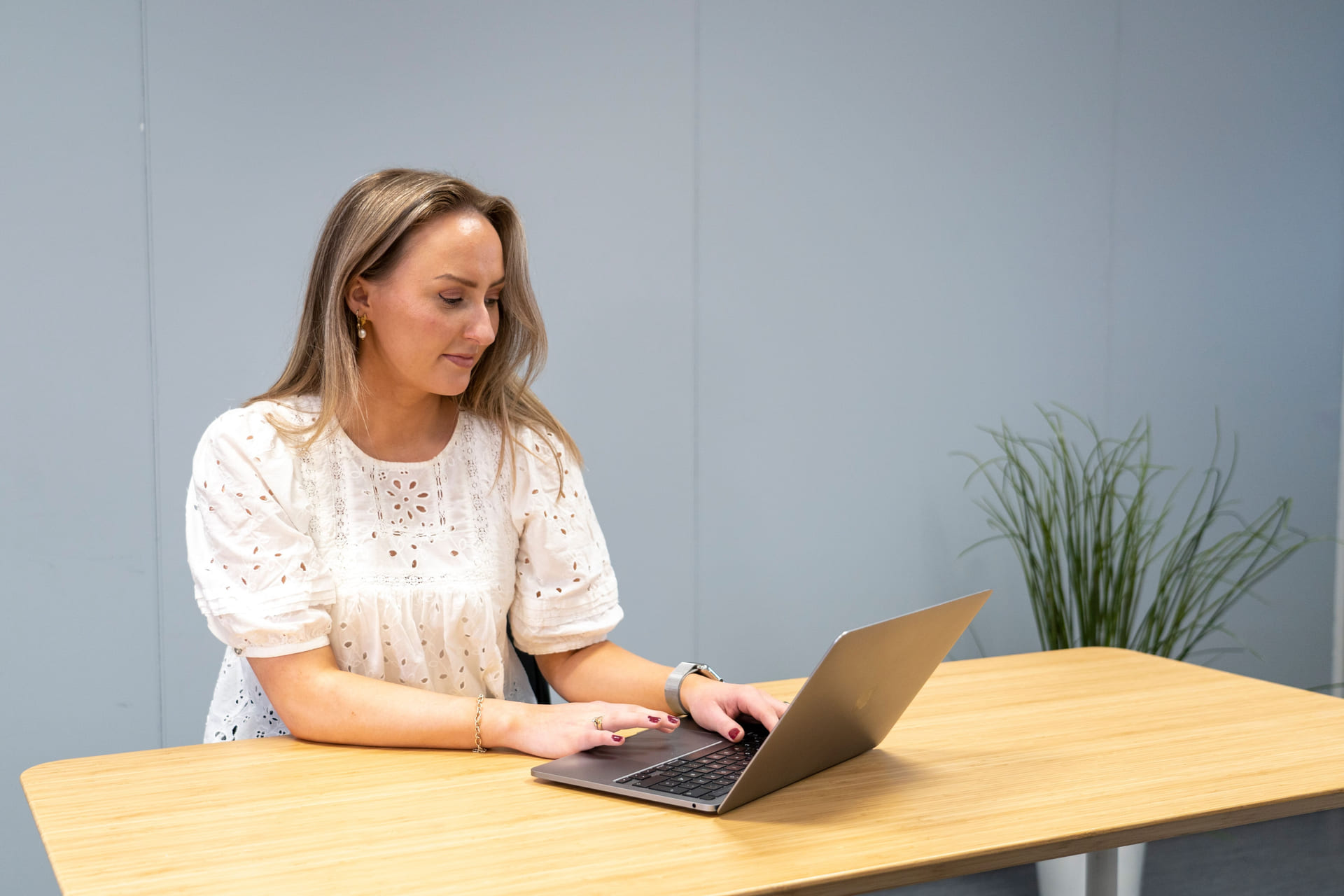 Jente jobber på en MacBook i et klassesrom