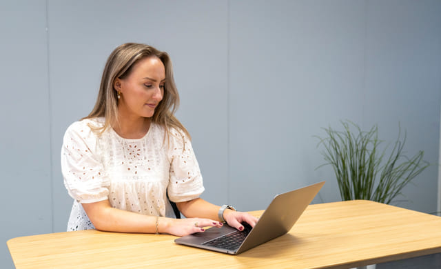 Jente jobber på en MacBook i et klassesrom