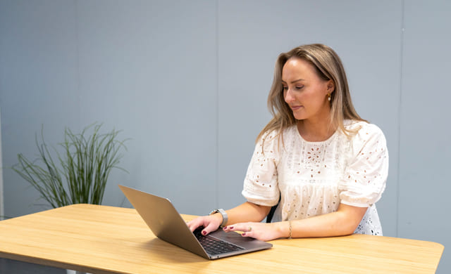 Jente jobber på en MacBook i et klassesrom