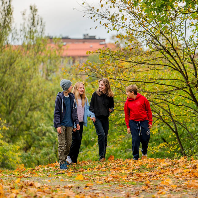 Elever på Akademiet Realfagsskole Oslo går i høstløvet utenfor skolen