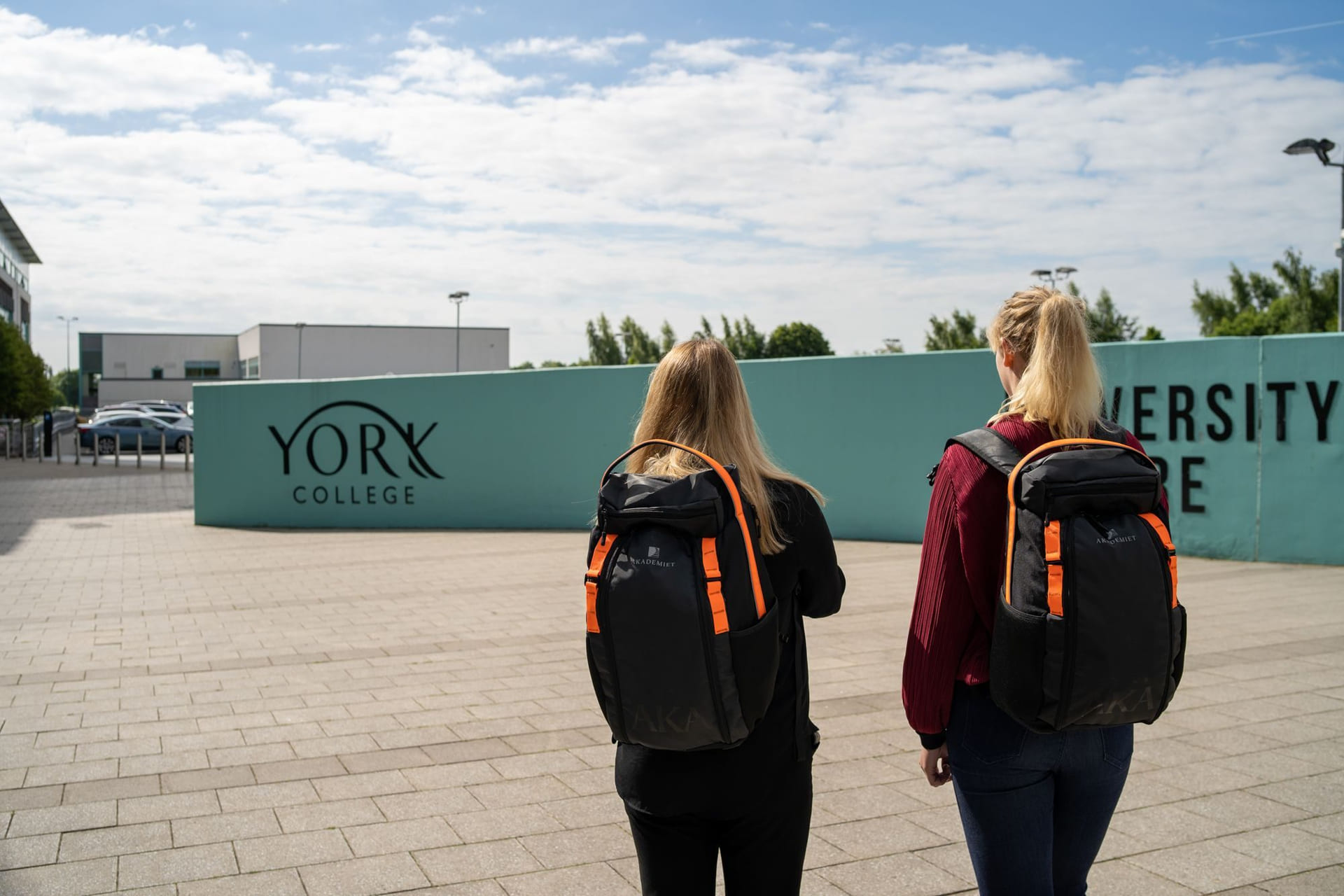 To personer står utenfor York College med Akademietsekker.