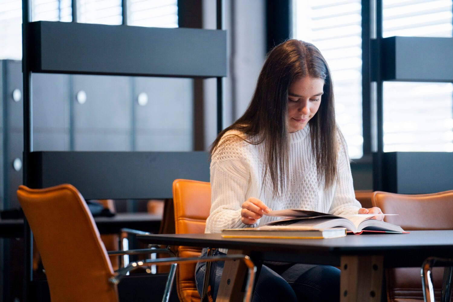 Jente leser en bok på Akademiet