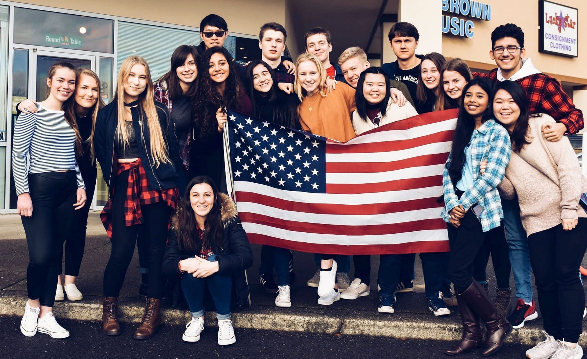En skoleklasse poserer med det amerikanske flagget.