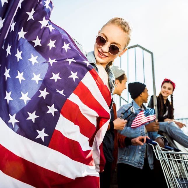 Jente holder opp det amerikanske flagget.