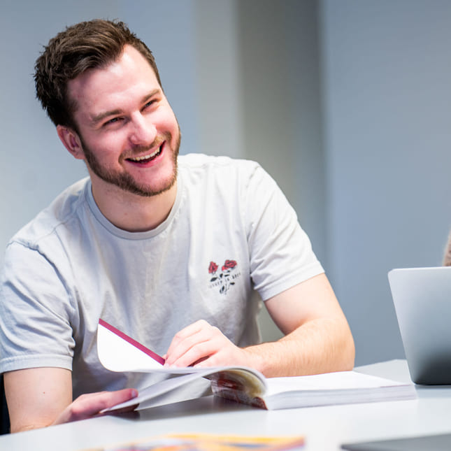 Privatister som jobber sammen rundt et bord. Foto.