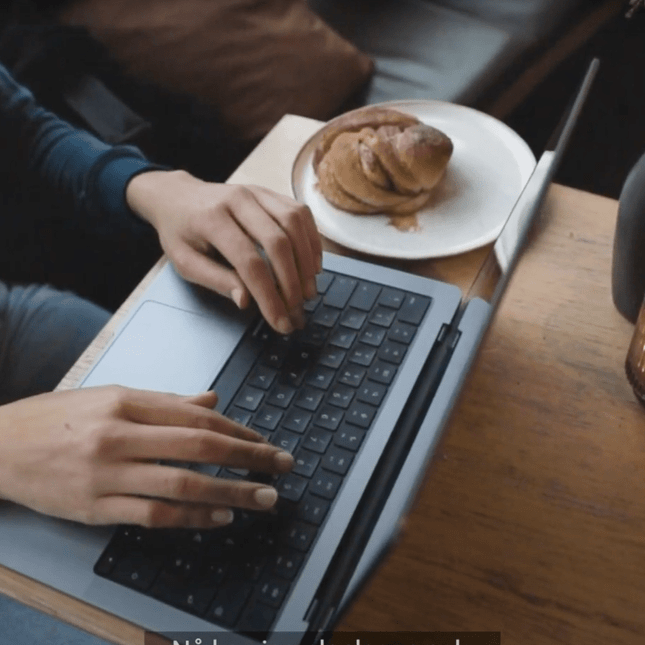 Privatist taster på en macbook på en kafé mens hun jobber med Akademiet nettstudier
