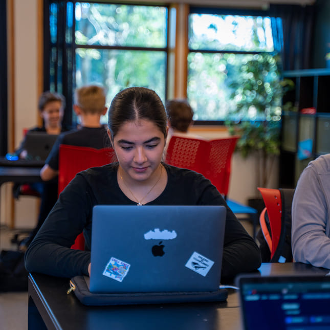 Elev på Akademiet Ungdomsskole Lier jobber fokusert på Macbook